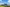 Photovoltaik- und Windkraftanlage auf einer grünen Wiese bei blauem Himmel.